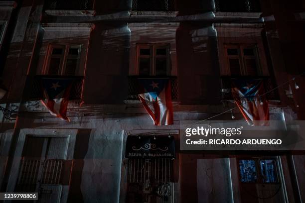 Puerto Rican flags hang from a balcony in San Juan, Puerto Rico after a major power outage hit the island on April 6, 2022.