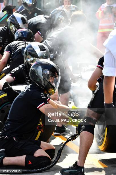 Mercedes' crew members practice pit stops outside the garage at the Albert Park Circuit in Melbourne on April 7 ahead of the 2022 Formula One...