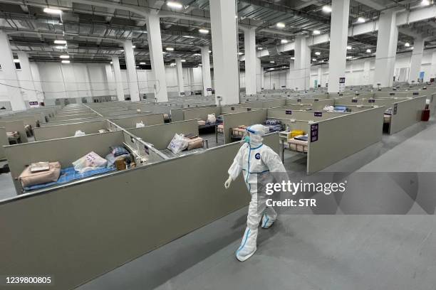 Staff member walks inside a makeshift hospital that will be used for Covid-19 coronavirus patients in Shanghai on April 7, 2022. - China OUT / China...