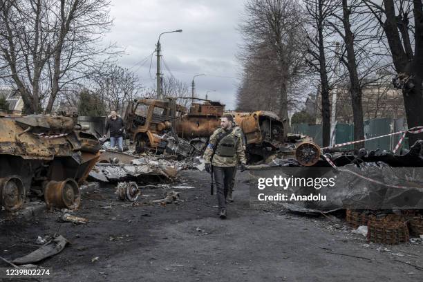 Ukrainian servicemen walk amid the destruction on a street in the town of Bucha, on the outskirts of Kyiv, after the Ukrainian army secured the area...