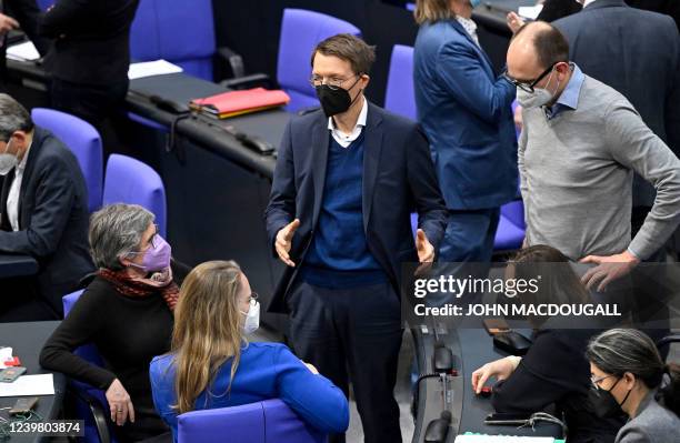 German Health Minister Karl Lauterbach speaks with MPs of the Green party as they wait for the results of the first resolution involving a mandatory...