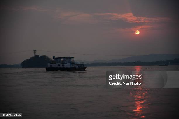 Commuters travel in a ferry as they cross the Brahmaputra river during Sunset in Guwahati ,india on April 7,2022..