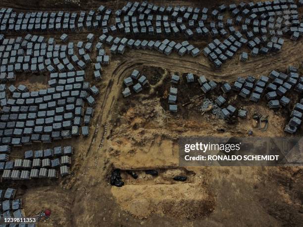 An aerial view shows body bags in a trench of a mass grave in the grounds surrounding the St Andrew church in Bucha, on April 7 amid Russia's...