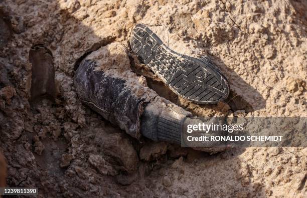 Picture shows an arm and a shoe in a mass grave in Bucha, on April 7 amid Russia's military invasion launched on Ukraine. - The UN humanitarian chief...