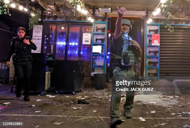 Policeman gestures at the scene in the aftermath of a shooting attack in Dizengoff Street in the centre of Israel's Mediterranean coastal city of Tel...