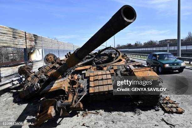 Car drives past a burnt Russian tank on a road west of Kyiv, on April 7 during Russia's military invasion launched on Ukraine. - Six weeks after...