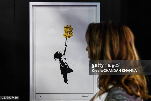 Woman looks at Bitcoin themed piece of art during the Bitcoin 2022 Conference at the Miami Beach Convention Center in Miami Beach, Florida, on April...
