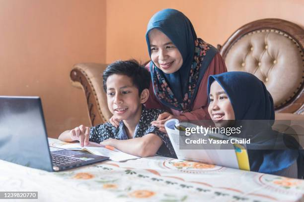 mother and son daughter homeschooling - hiyab fotografías e imágenes de stock