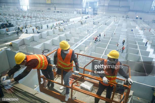 This photo taken on April 7, 2022 shows employees working at a makeshift hospital that will be used for Covid-19 coronavirus patients in Shanghai. -...