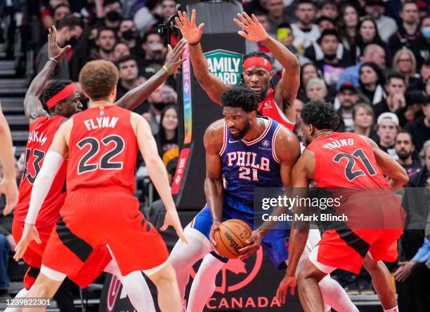 Joel Embiid of the Philadelphia 76ers is guarded by Thaddeus Young, Malachi Flynn, Pascal Siakam, and Precious Achiuwa of the Toronto Raptors during...