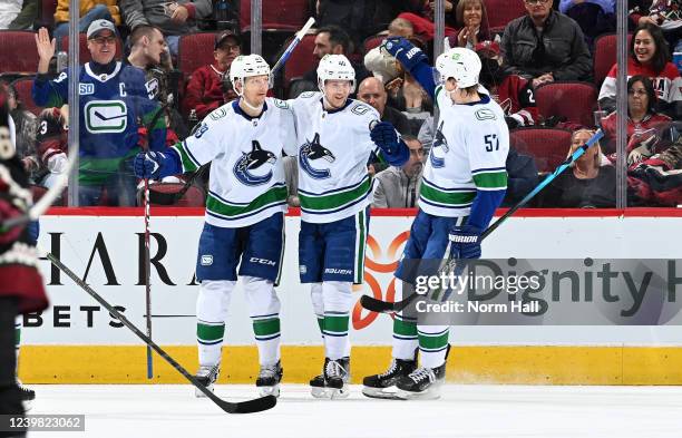 Elias Pettersson of the Vancouver Canucks celebrates with Alex Chiasson and Tyler Myers after scoring a goal against the Arizona Coyotes during the...