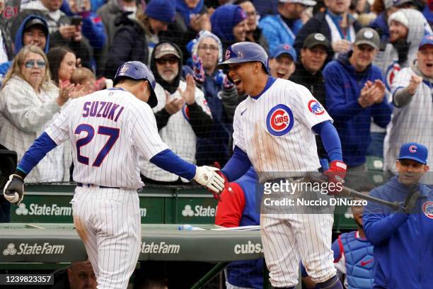 Seiya Suzuki of the Chicago Cubs is greeted by teammate Rafael Ortega after scoring a run during the game between the Milwaukee Brewers and the...