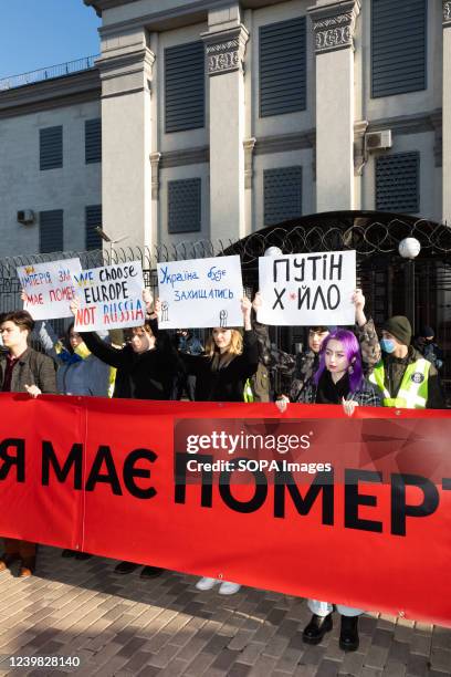 Protesters hold a banner that says " Empire must die and Glory to the nation - death to enemies" in front of the Embassy of the Russian Federation in...