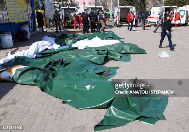 Graphic content / Casualties covered in tarpaulin are lied out on the platform in the aftermath of a rocket attack on the railway station in the...