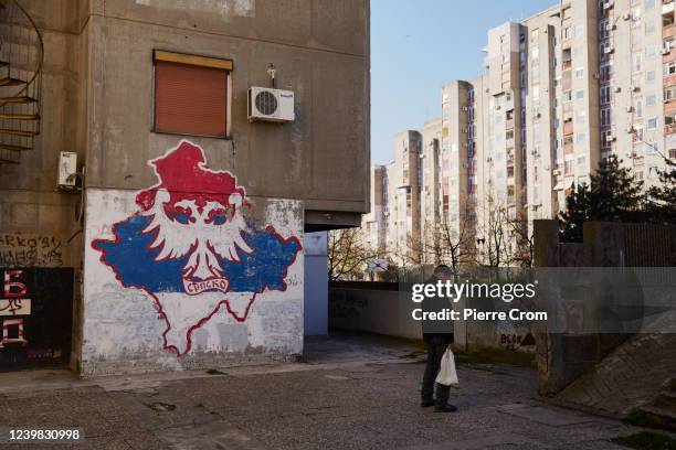 Local resident stands near a mural depicting Kosovo in the color of the Serbian flag in a residential area called New Belgrade on April 6, 2022 in...