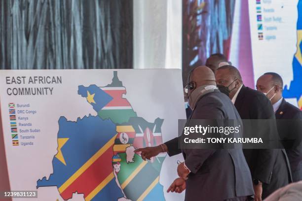 Presidents Uhuru Kenyatta and Democratic Republic of Congo President Felix Tshisekedi look at the new depiction of the East Africa Community on a map...
