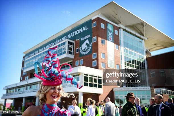 Racegoer smiles as she attends the "Ladies day" on the second day of the Grand National Festival horse race meeting, at Aintree Racecourse, in...