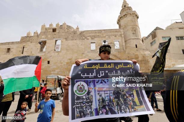 Youth lifts a placard as supporters of the Palestinian Hamas and Islamic Jihad militant group rally after Friday prayers in Khan Yunis The Southern...