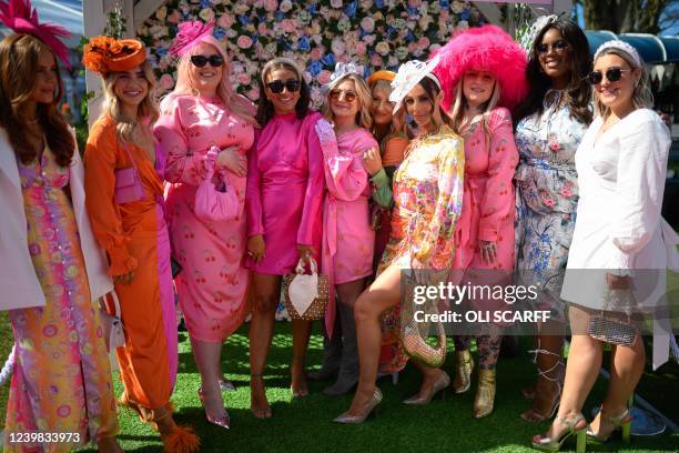 Racegoers pose for pictures as they attend the "Ladies day" on the second day of the Grand National Festival horse race meeting, at Aintree...