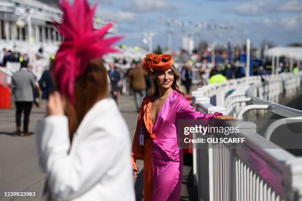 Racegoer looks on as she attends the "Ladies day" on the second day of the Grand National Festival horse race meeting, at Aintree Racecourse, in...