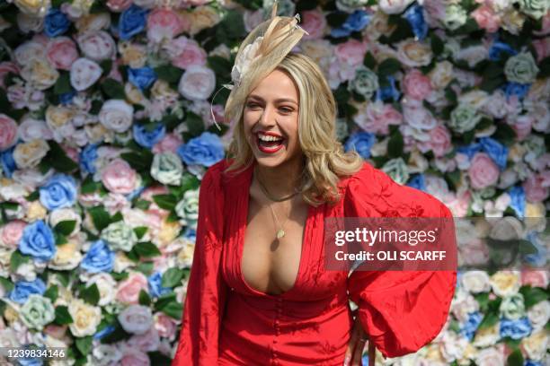 Racegoer poses for pictures as she attends the "Ladies day" on the second day of the Grand National Festival horse race meeting, at Aintree...