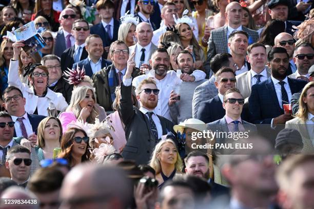 Racegoers cheer as they watch the third race during the second day, "Ladies Day", of the Grand National Festival horse race meeting, at Aintree...