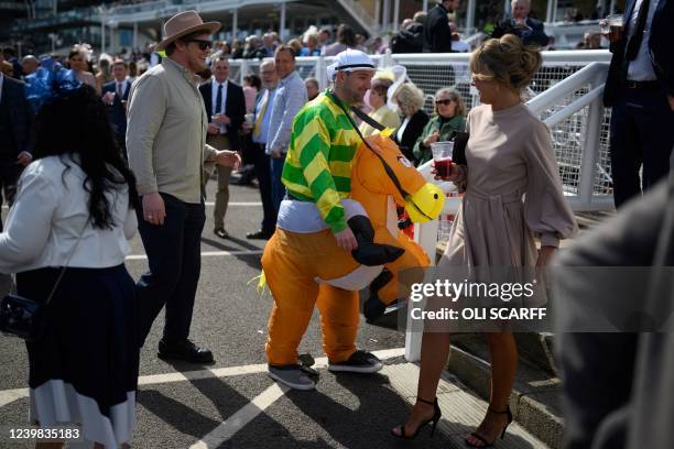 Racegoer dressed-up as a jockey on a horseback attends the second day, "Ladies Day", of the Grand National Festival horse race meeting, at Aintree...