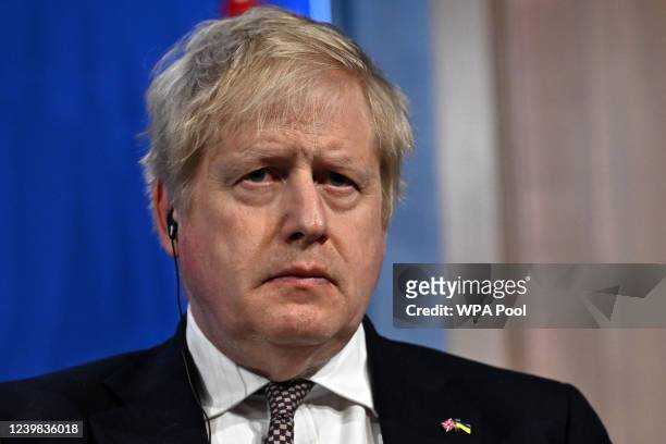 Britain's Prime Minister Boris Johnson listens during a joint press conference with Germany's Chancellor Olaf Scholz inside the Downing Street...