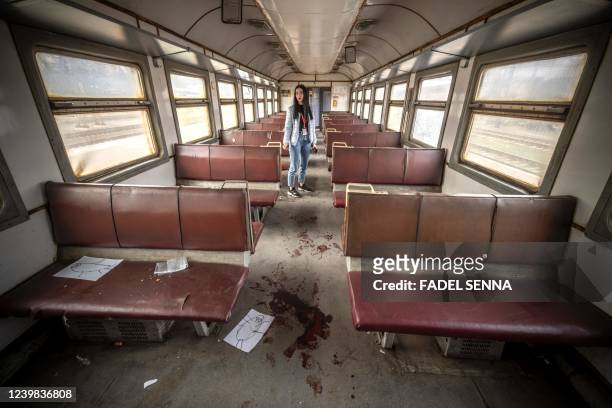 Graphic content / A woman stands in a train car after a rocket attack on a train station in Kramatorsk, eastern Ukraine, on April 8, 2022. - A rocket...