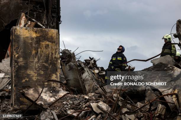 Firefighters work amidst the rubble of destroyed buildings in the town of Borodianka, northwest of Kyiv, on April 8, 2022.