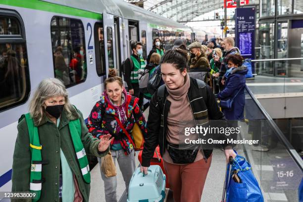 Volunteers with green jackets provide assistance to Ukrainians fleeing the war in Ukraine as they disembark from a train coming from Warsaw at...