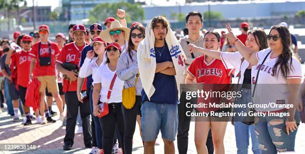 Anaheim, CA Dodger fan Michael Martinez stands motionless as Angel fans, including his girlfriend, Melissa Rios, to his right, make fun of him while...