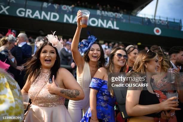 Racegoers cheer as they watch a race on the second day, "Ladies Day", of the Grand National Festival horse race meeting, at Aintree Racecourse, in...