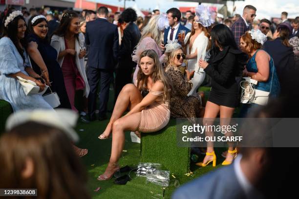 Racegoers attend on the second day, "Ladies Day", of the Grand National Festival horse race meeting, at Aintree Racecourse, in Liverpool, north west...
