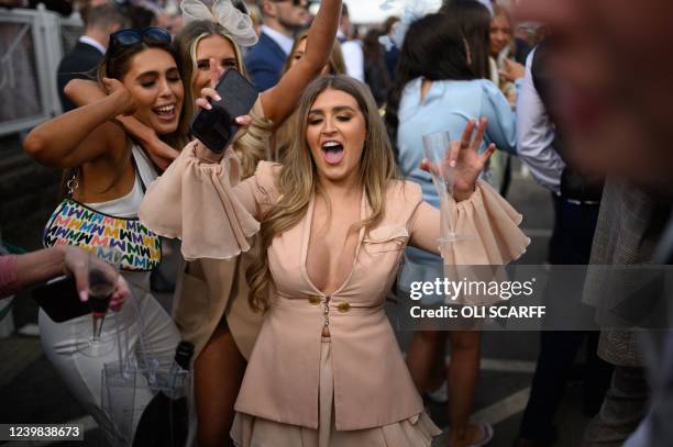 Racegoers enjoy themselves on the second day, "Ladies Day", of the Grand National Festival horse race meeting, at Aintree Racecourse, in Liverpool,...