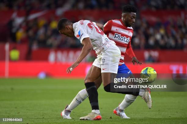 Sevilla's French forward Anthony Martial vies with Granada's Cameroonian midfielder Yan Brice Eteki during the Spanish League football match between...