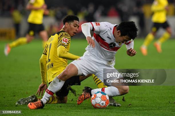 Dortmund's English midfielder Jude Bellingham and Stuttgart's Japanese midfielder Wataru Endo vie for the ball during the German first division...