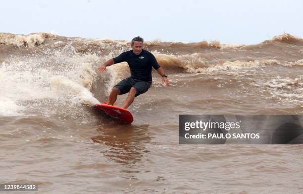 Brazilian surfer Fabio Gouveia drops a wave into the waters of the mouth of the Amazon River, in an area known as Canal do Perigoso, to catch the...