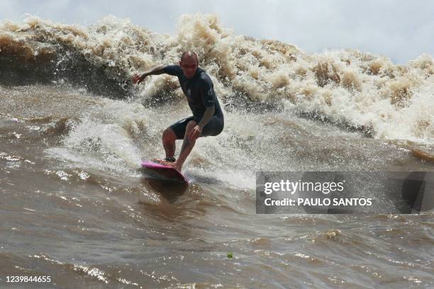 Brazilian surfer Raoni Monteiro drops a wave into the waters of the mouth of the Amazon River, in an area known as Canal do Perigoso, to catch the...