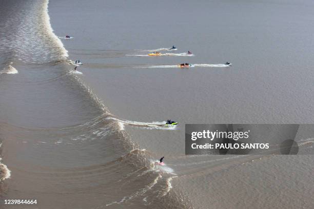 Aerial view of Brazilian surfers venturing into the waters of the mouth of the Amazon River, in an area known as Canal do Perigoso, to catch the...
