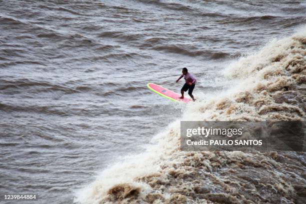 Aerial view of Brazilian surfer Marcelo Bibita dropping a wave into the waters of the mouth of the Amazon River, in an area known as Canal do...