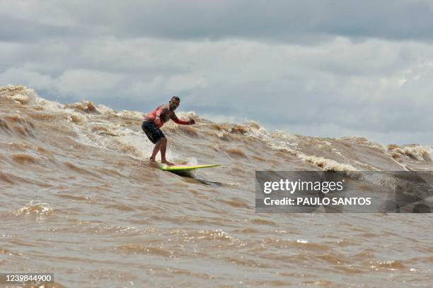 Brazilian surfer Marcelo Bibita drops a wave into the waters of the mouth of the Amazon River, in an area known as Canal do Perigoso, to catch the...