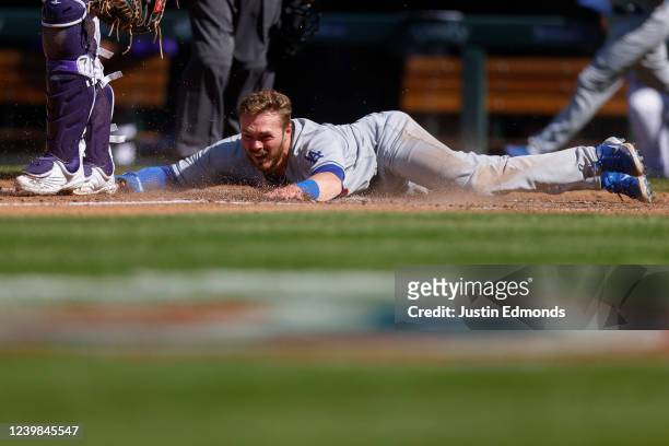 Gavin Lux of the Los Angeles Dodgers slides in to score on a double off the bat of Mookie Betts in the fourth inning against the Colorado Rockies on...
