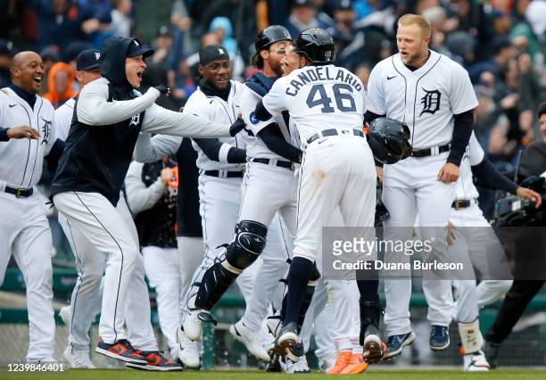 Javier Baez of the Detroit Tigers celebrates in the arms of Jeimer Candelario and catcher Eric Haase, along with Austin Meadows, right, after hitting...