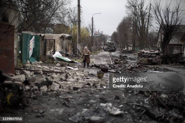 An elder woman walks amid destruction on a street in the town of Bucha, on the outskirts of Kyiv, after the Ukrainian army secured the area following...