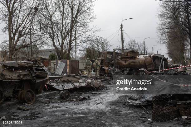 Ukrainian servicemen inspect the wreckage of Russian military vehicles in the town of Bucha, on the outskirts of Kyiv, after the Ukrainian army...