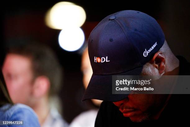 An attendee wears a cap with the logo of bitcoin that reads "hodl", slang in the cryptocurrency community for holding a cryptocurrency rather than...