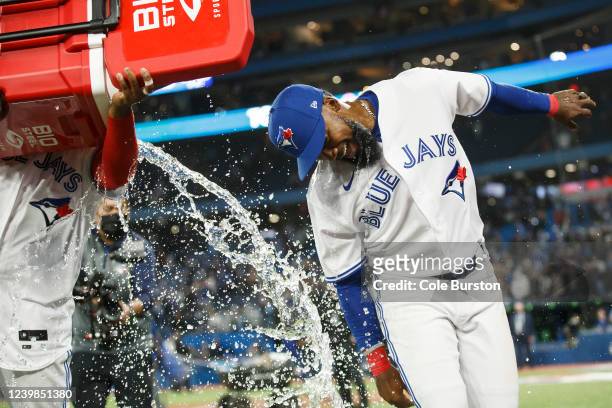 Vladimir Guerrero Jr. #27 dumps water on Teoscar Hernandez of the Toronto Blue Jays as they celebrate their win over the Texas Rangers on Opening Day...
