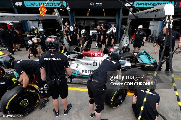 Crew members practice pit stops with the car of Mercedes' British driver George Russell prior to the final practice session at the Albert Park...