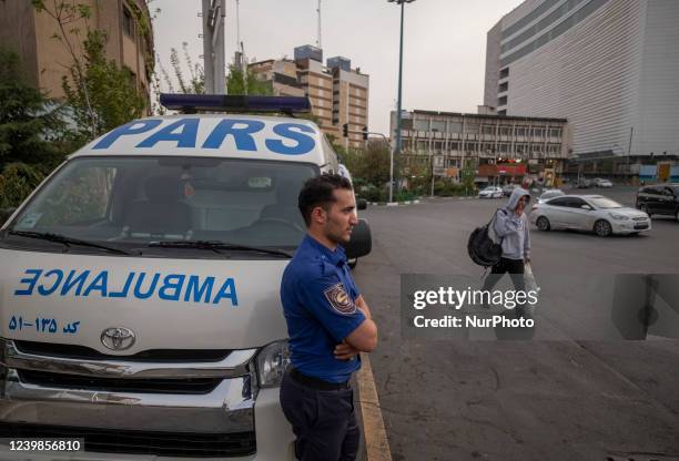 Health personnel stands next to an ambulance on a corner of a square in Tehran during a polluted air, on April 8, 2022.